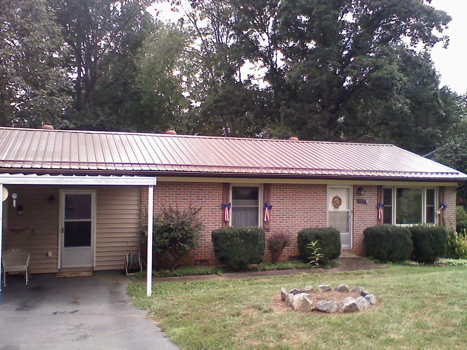 Bronze metal roof and carport on a brick ranch home — Roof Repair work by our crew in Union Mills